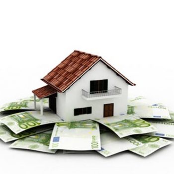 Une maison est bâtie sur des fondations en billets de banque, représentant l'économie d'argent que prodigue les investissements dans l'immobilier grâce au taux immobilier actuel qui est au plus bas.